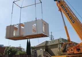 crane lowering a modular house onto foundation